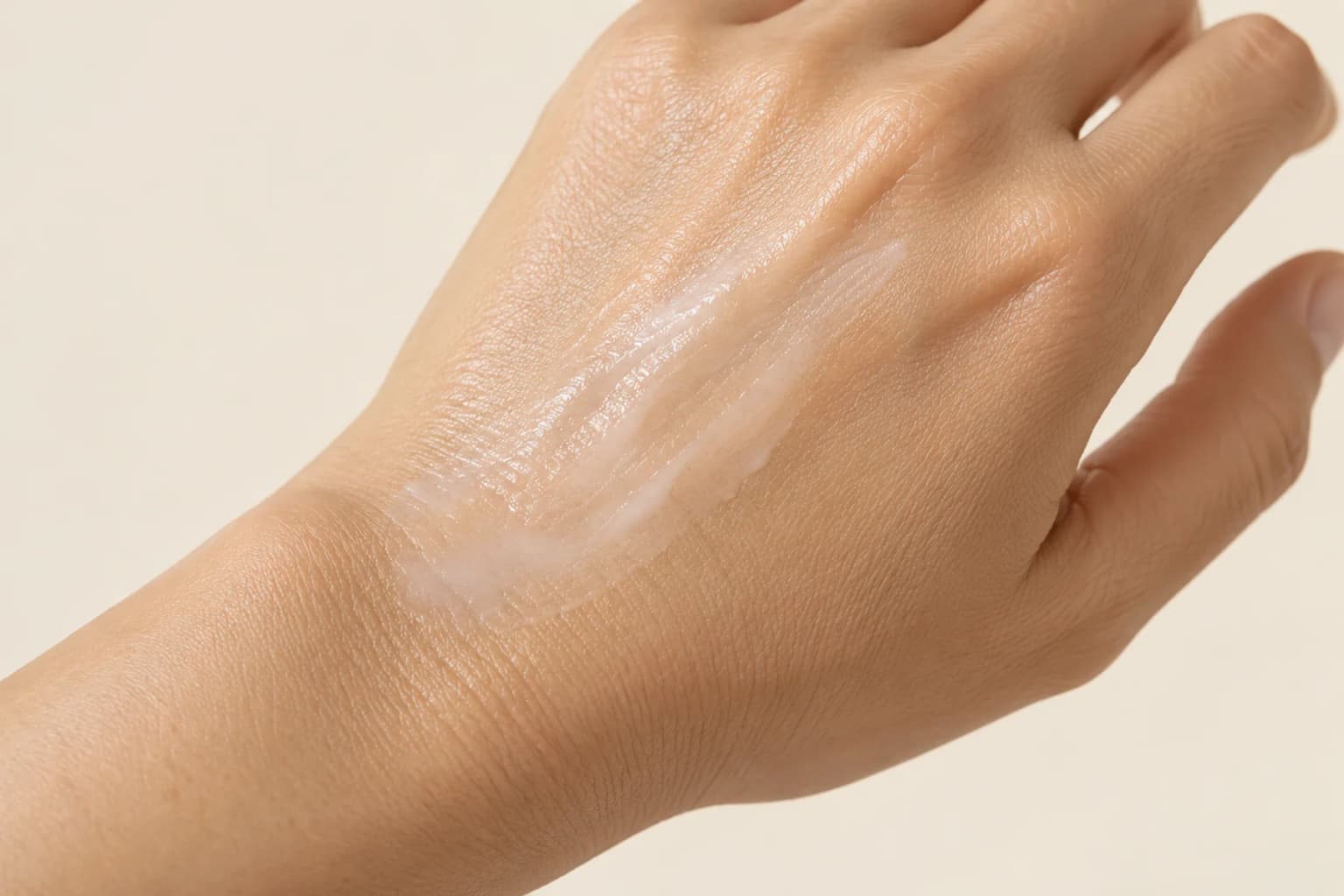 An even thin serum layer on a naturally textured hand, without a comparison or skin-effect measurement. Editorial illustration.