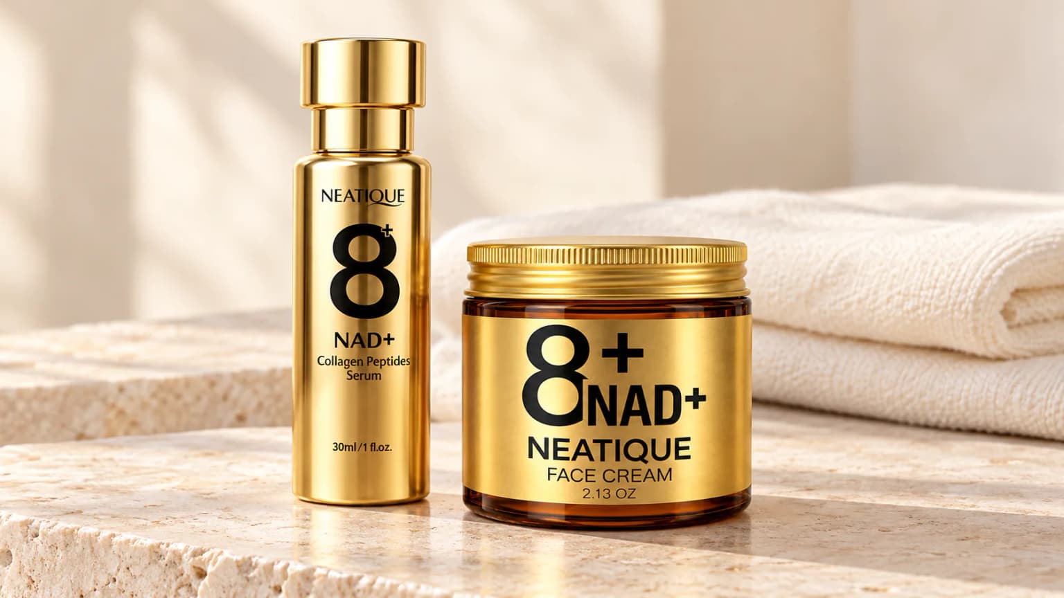 Labeled Neatique NAD+ Face Cream and Serum on pale stone with a folded ivory cloth behind them